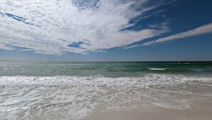 A beach with waves, a clear sky, and a distant horizon. - Sand n Stars (Panama City Beach)