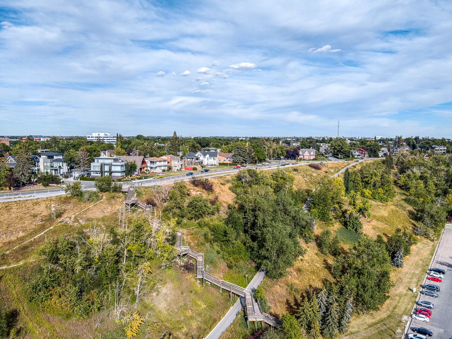 A residential area with houses, a road, and a parking lot.