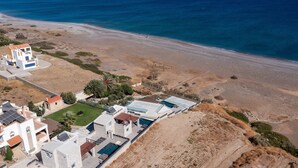 An aerial view of a coastal property with a swimming pool, multiple buildings, and a beach. - Southrock Villas - 6 Bed Superb Seaview Villa with Private Pool (New Listing) (Lachania)