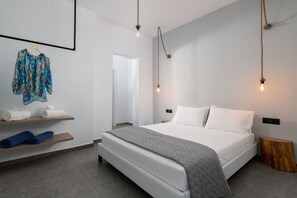 Une chambre moderne avec un grand lit, des étagères en bois et un luminaire suspendu.