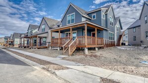 A row of modern, two-story houses with wooden decks and stairs leading to the entrance. - Midgarth Hus- Brand New PET FRIENDLY home minutes to Copper & Ski Cooper! (Leadville)