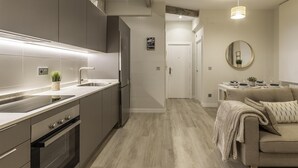 A modern kitchen with grey cabinets, a stainless steel sink, and a built-in oven. - Recién reformado junto a metro San Mamés (Bilbao)