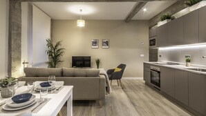 A modern living room with a sofa, dining table, and kitchen area. - Recién reformado junto a metro San Mamés (Bilbao)