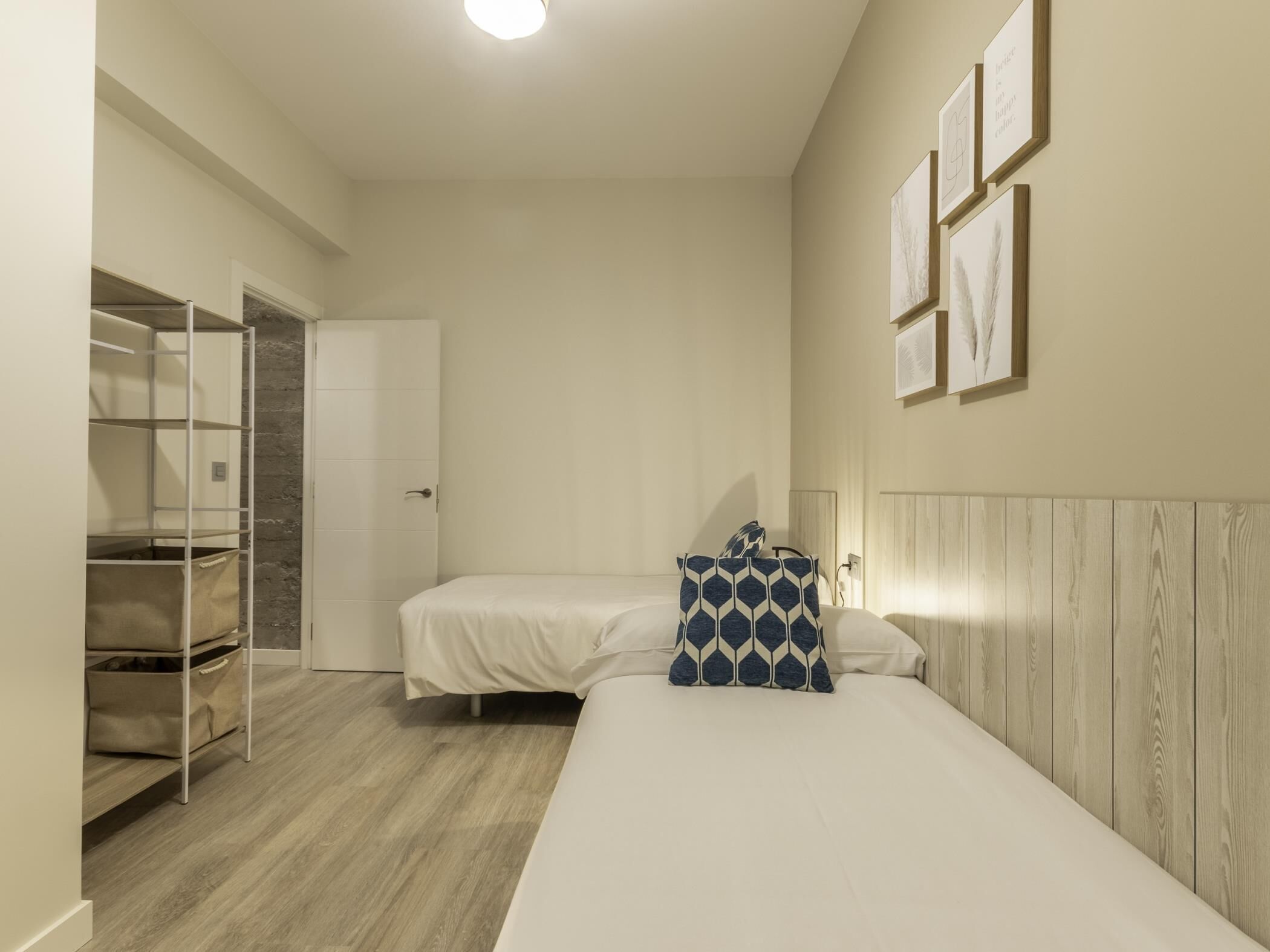 Een kamer met twee bedden, een kast en een plankunit.