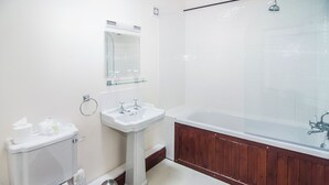 A bathroom with a toilet, sink, and bathtub. - This charming barn conversion is ideal for a large family holiday. (Sculthorpe, Fakenham)