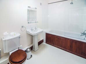 A bathroom with a toilet, sink, and bathtub.