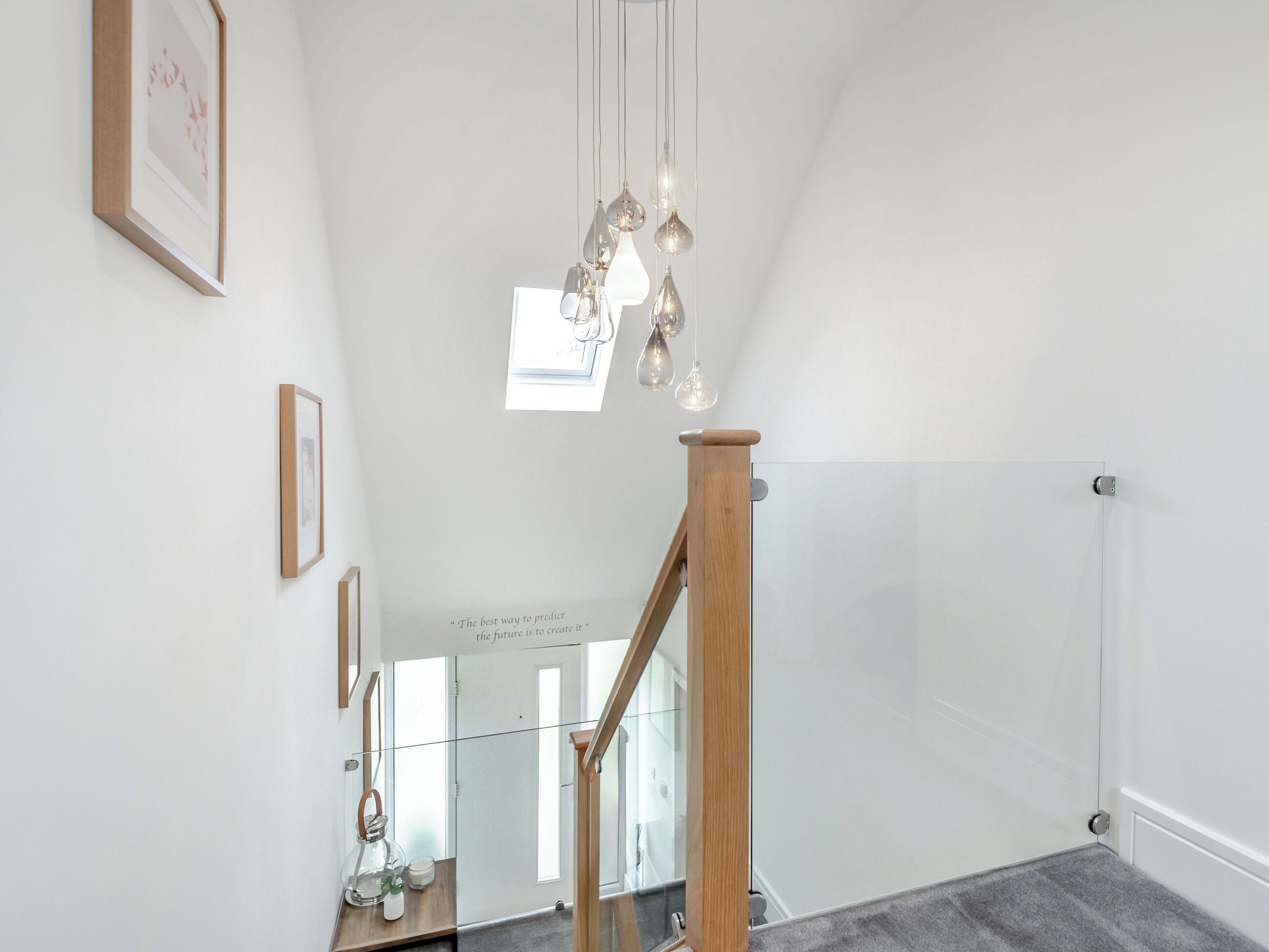 Ein modernes Interieur mit einer Holztreppe, Glastrennlärm und Pendelleuchten.