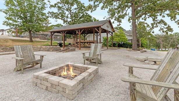 An outdoor seating area with a fire pit and Adirondack chairs.