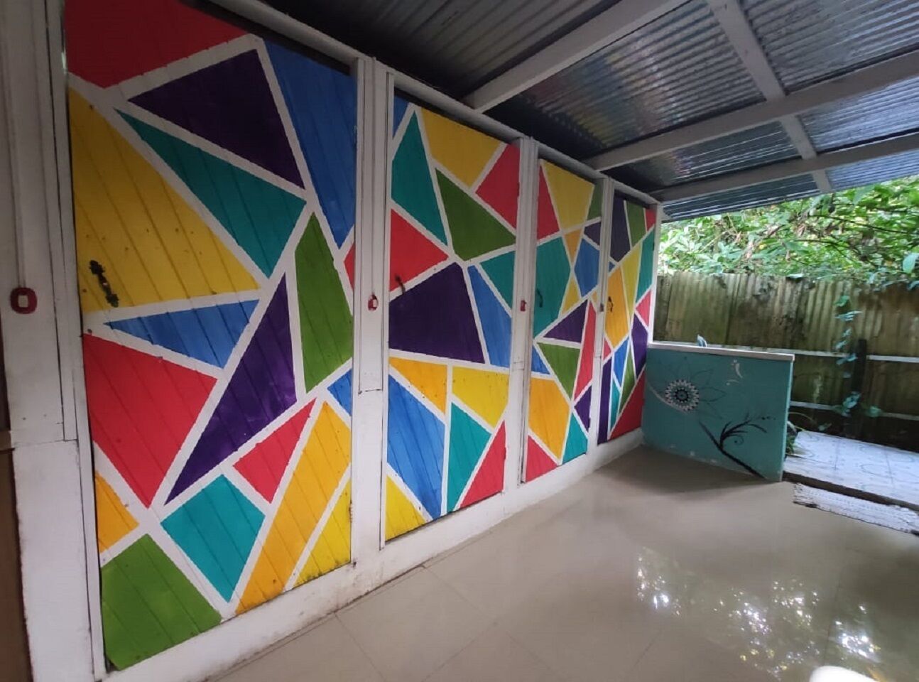 A covered outdoor area with colorful geometric patterns on the walls and a tiled floor.
