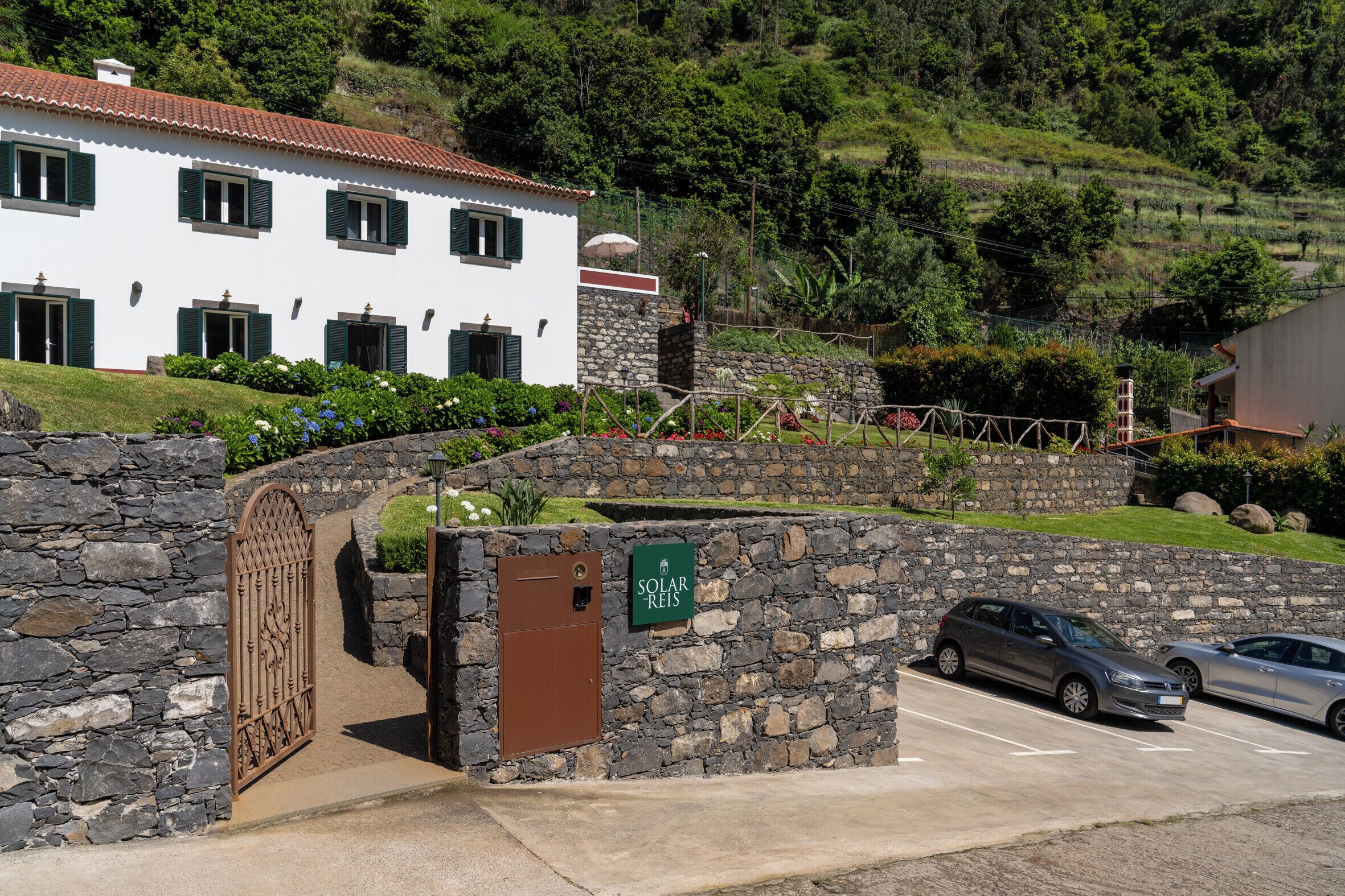 A stone wall entrance with a sign for Solar Reis.