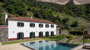 A white villa with a swimming pool, surrounded by a garden and a hilly landscape. - Solar dos Reis 6, double room with breakfast (Ribeira Brava)
