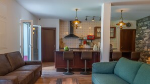 A modern kitchen with a central island, bar stools, and pendant lighting. - Solar dos Reis 6, double room with breakfast (Ribeira Brava)