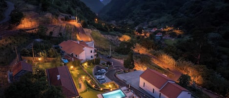 A residential area with houses, a swimming pool, and a winding road.