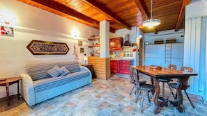Un espacio de sala acogedor con un sofá, una mesa de comedor de madera y sillas.