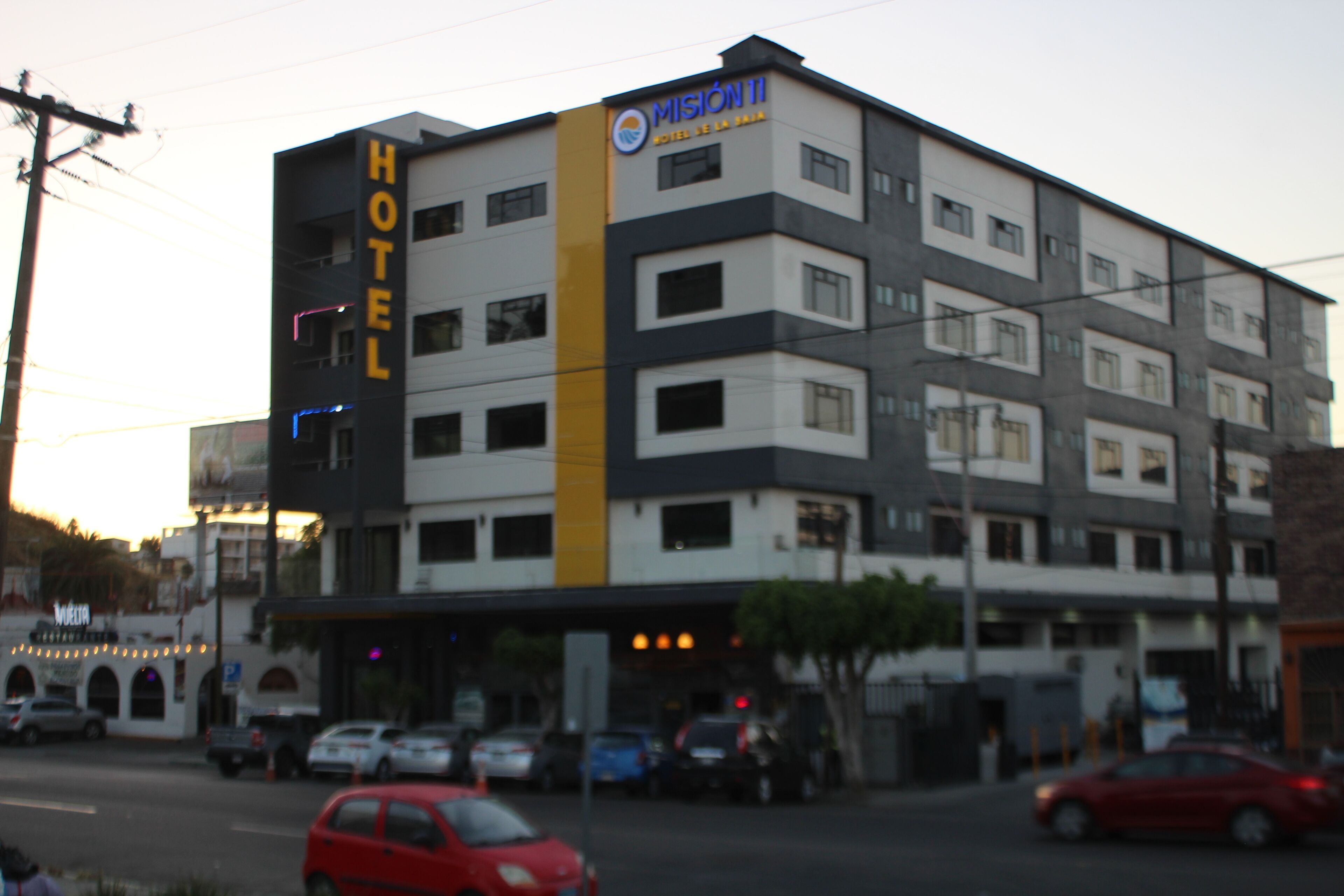 Un hôtel à plusieurs étages, dont la façade est ornée d’une grande enseigne indiquant « HÔTEL ».