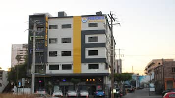 Un hotel de varios pisos con una llamativa franja amarilla y un letrero que indica que es el 'Mision II Hotel de la Sierra'.