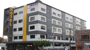A multi-story hotel with a modern design, featuring a prominent yellow stripe and the name 'MISIÓN HOTEL' on the facade. - MISION 11 (Tijuana)