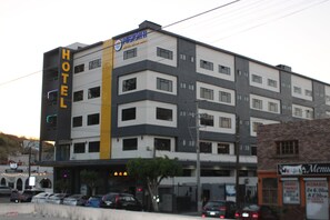 Un hotel de varios pisos con un llamativo letrero que dice 'HOTEL' en la fachada.