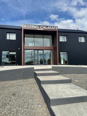 Un hotel moderno con un cartel llamativo que dice 'DESTINO CALAFATE HOTEL'.