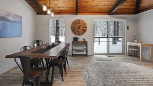 A dining area with a wooden table, chairs, and a large wall clock. - 12 Quartz Mtn - Updated and Classy! Pickleball, SHARC, Fireplace, Backs to Sunriver Forest (Sunriver)