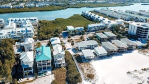 An aerial view of a coastal resort with multiple buildings, a beach, and a body of water. - Welcome to Paradise Cove! - Steps From The Beach (Indian Shores)