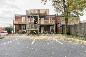 A two-story building with a wooden deck and a staircase leading to the upper floor. - Newly Renovated 2BR Apartment w/ Free Parking in Downtown (Lexington)