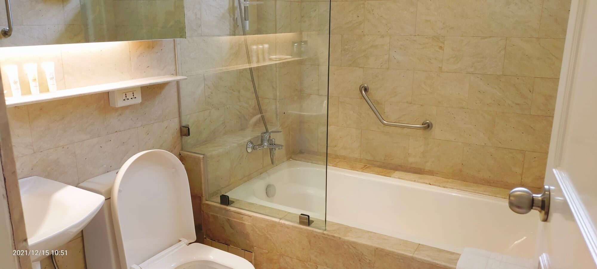 Een badkamer met een bad, toilet en douchecabine.