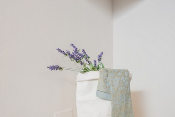 A white towel with a blue and gold pattern hanging on a white wall.