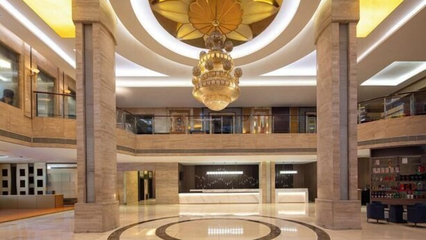 Um hall amplo com design circular central, um lustre grande e estilo arquitetônico moderno.