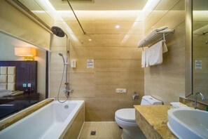 Uma casa de banho moderna com banheira, sanita e lavatório.