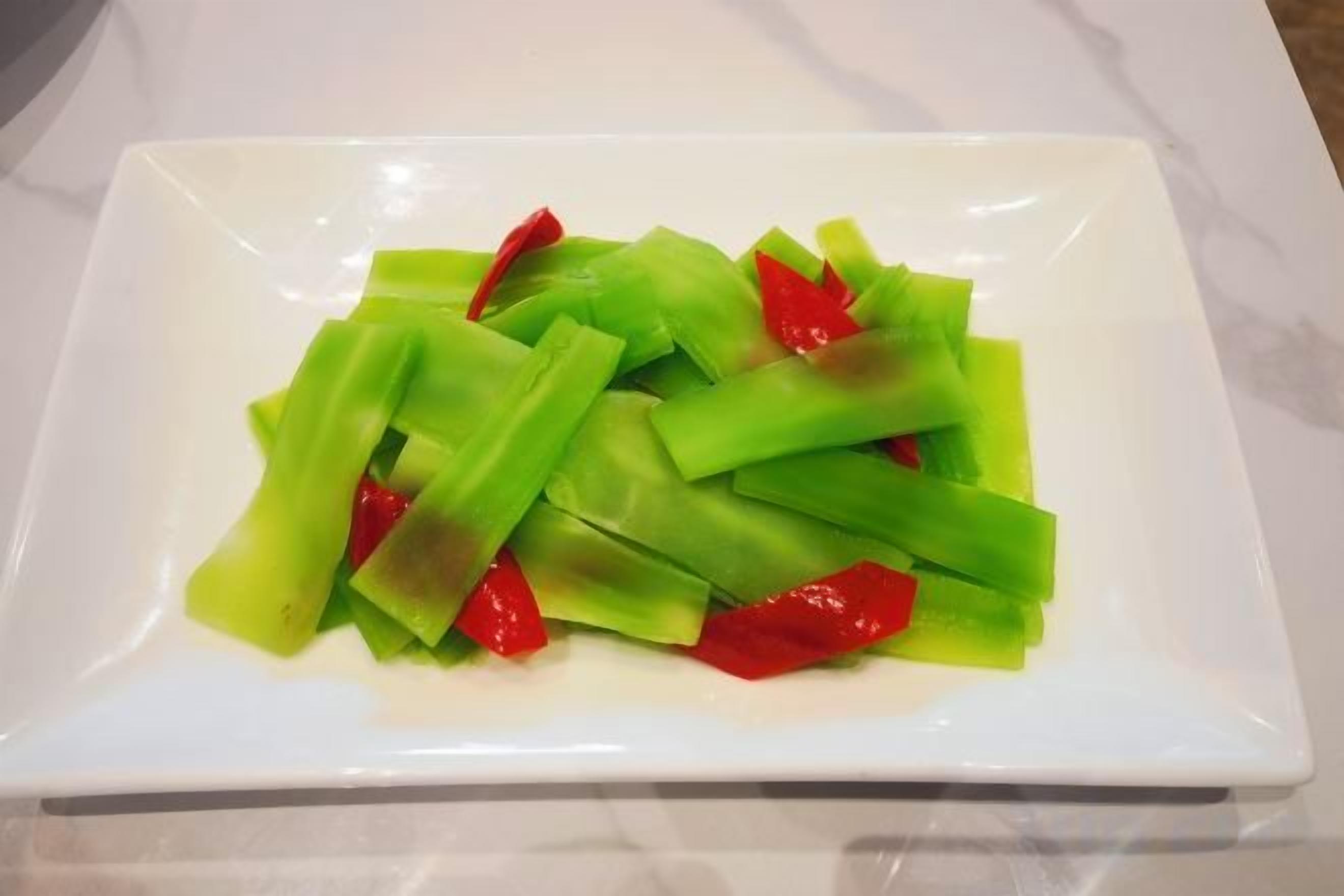 A white plate with green and red vegetable slices.
