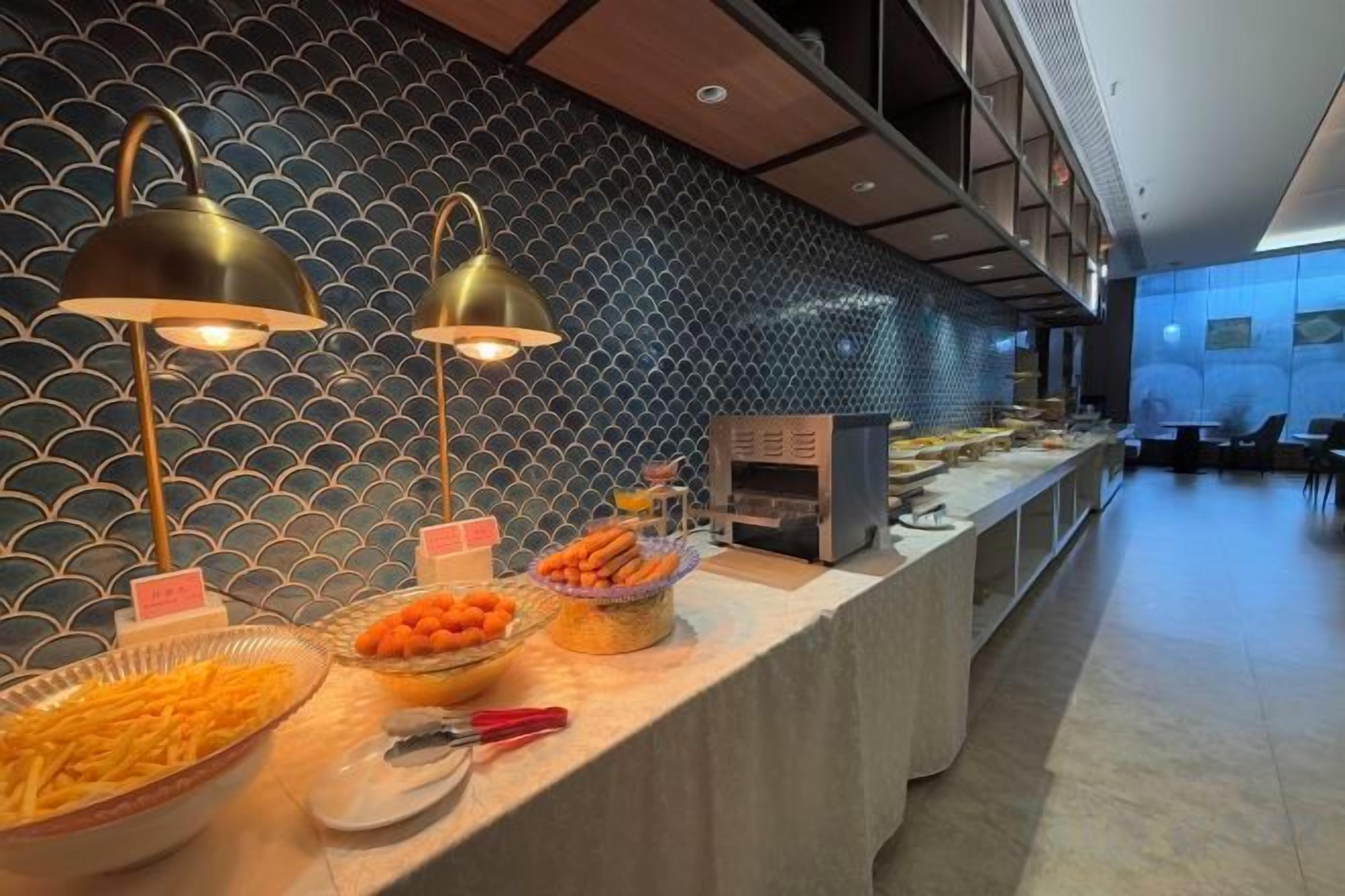 A buffet setup with various food items and a modern interior design.