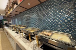 A buffet area with multiple food service stations and a decorative tiled wall.