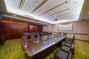A conference room with a long table, multiple chairs, and a projector screen. - Ramada Hotel Zhangjiajie (Tianmen Mountain Cable Car Station) (Zhangjiajie)