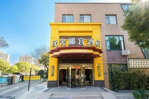 A hotel entrance with a yellow facade and black signage. - Hanshe Ligong Hotel (Shanghai Dahongqiao National Convention and Exhibition Center) (Shanghai)