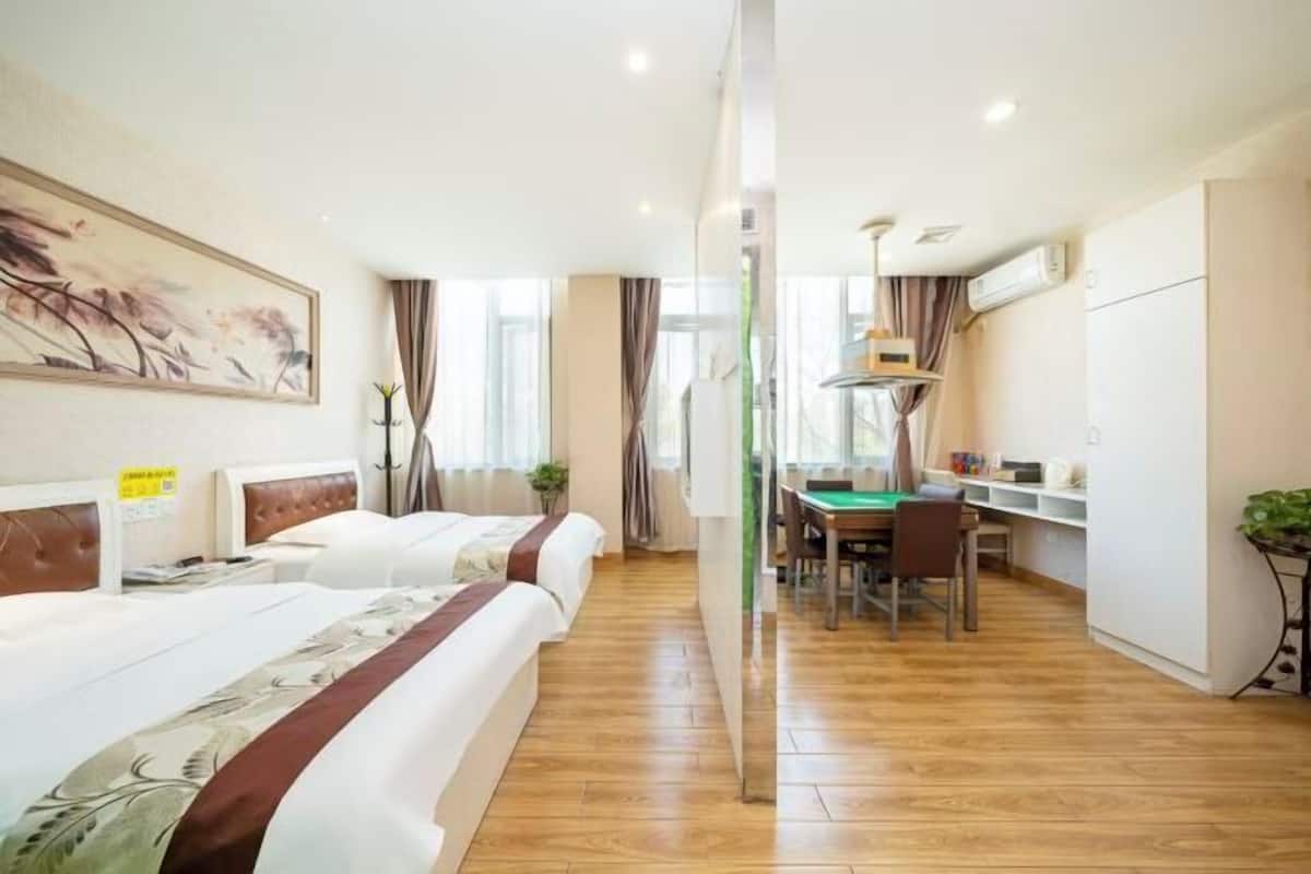 Una habitación de hotel con dos camas, un escritorio y una zona de comedor.
