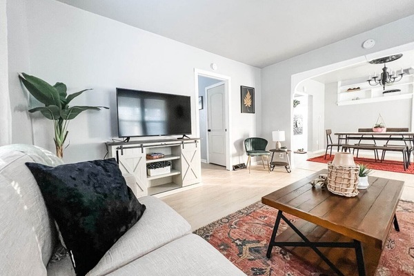 Spacious living room with smart TV & wrap-around sofa! Doorway to right of TV leads into downstairs bedroom with attached half-bath!