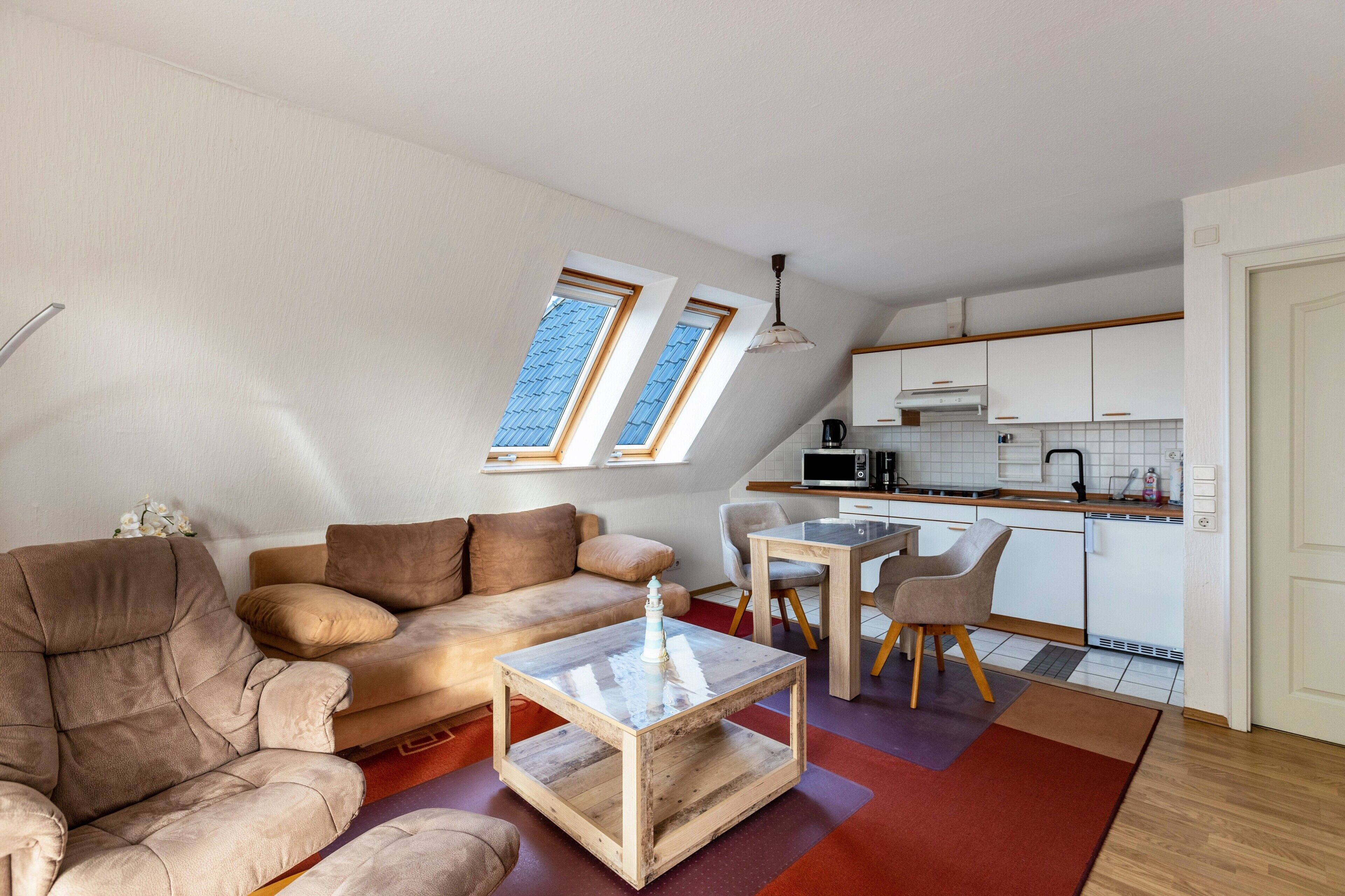 A loft-style apartment with a living area, kitchenette, and a dining space.