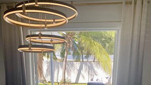 Een moderne eetruimte met een glazen tafel, metalen stoelen en een bijzondere ronde lamp.