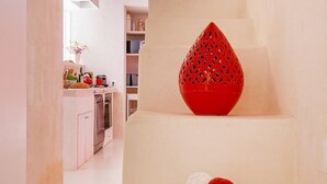 A narrow hallway with a staircase leading to a higher level. A red decorative object is placed on the top step.