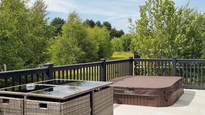 A deck with wicker furniture and a hot tub. - 1 bedroom accommodation in Woodhall Spa (Woodhall Spa)