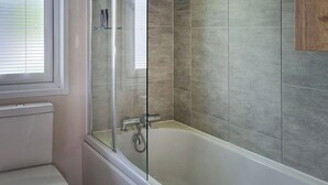 A bathroom with a glass-enclosed shower, a bathtub, and a toilet. - 1 bedroom accommodation in Woodhall Spa (Woodhall Spa)