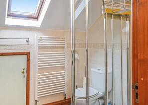 A bathroom with a skylight, a glass shower enclosure, a toilet, and a towel rack. - 2 bedroom accommodation in Dolgellau (Dolgellau)