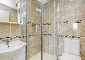 A bathroom with a glass-enclosed shower, a sink, and a toilet. - Compact lodge finished to a high standard with one double and one with bunks. (Pickering)