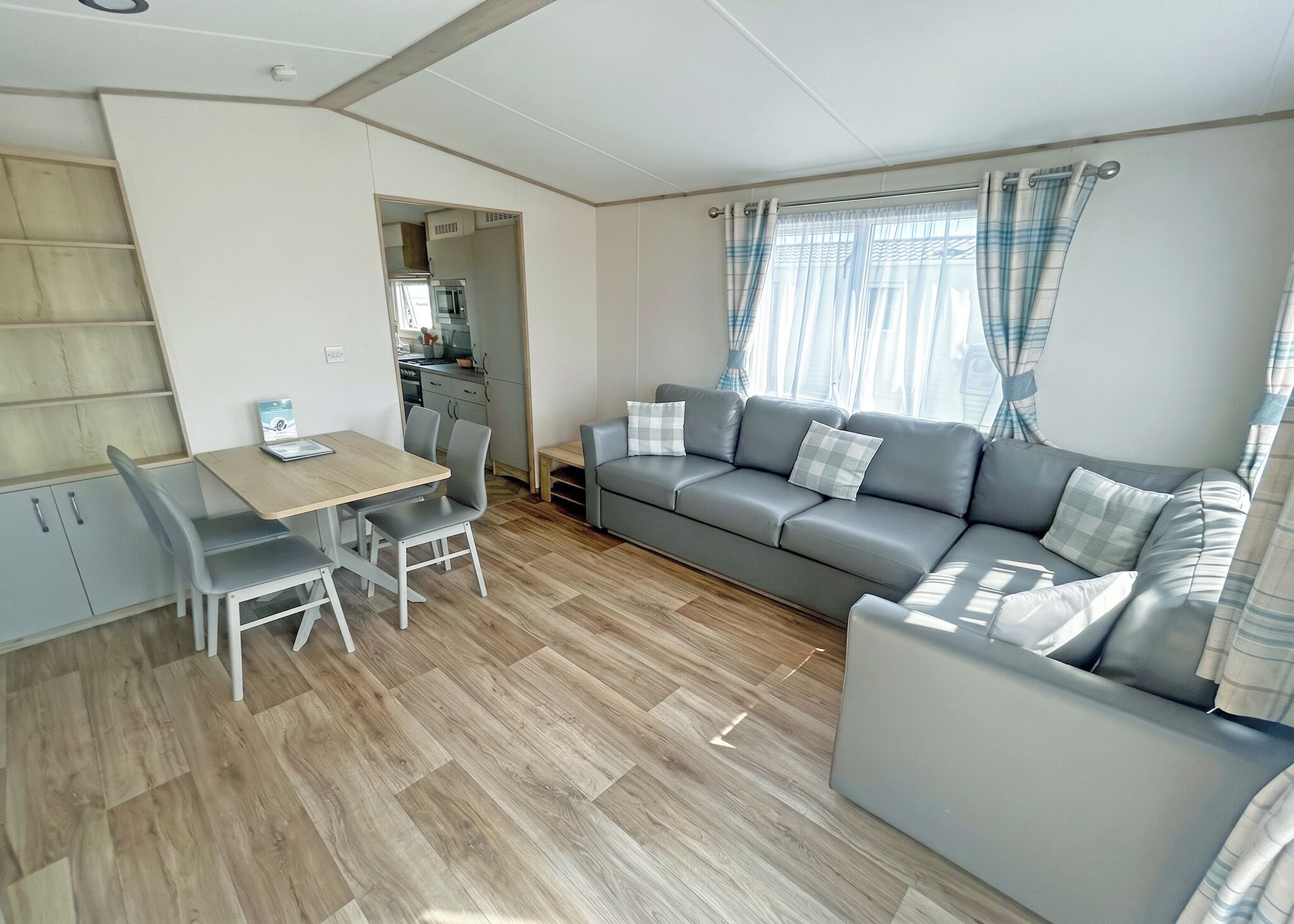Un espacio habitable funcional con comedor, sofá y kitchenette.