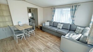 Ein kompakter Wohnbereich mit Essplatz, einer Couch und einer Küchenzeile.