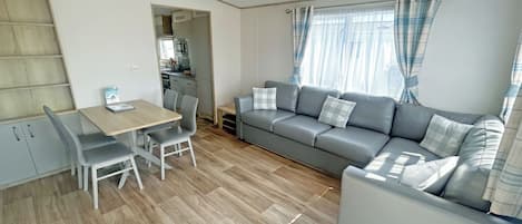 Un espacio habitable funcional con comedor, sofá y kitchenette.