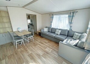 Un espacio habitable funcional con comedor, sofá y kitchenette.