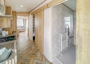 Una cocina moderna con suelo de espiga, armarios de madera y horno empotrado.