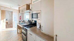 Eine moderne Küche mit Gasherd, Backofen, Mikrowelle und Edelstahlgeräten.